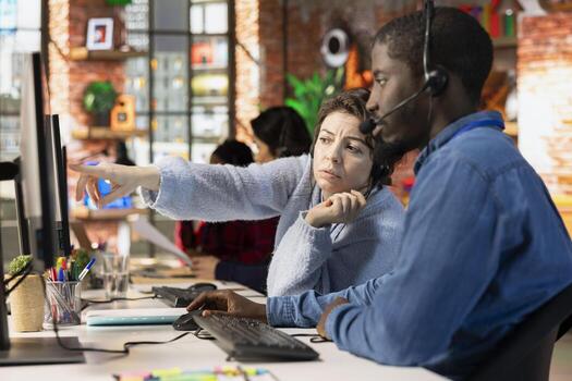 Call center agents brainstorming answers to customers technical inquiries about network issue. Customer support coworkers cooperating to troubleshoot problems using computer photo
