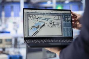 Technician using laptop to monitor solar panel manufacturing plant assembly lines. Close up of worker using notebook to troubleshoot photovoltaic equipment, ensuring seamless production workflow photo