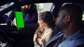 Salesman using green screen tablet to present car addons options to clients, after finishing test drive. Showroom agent mockup device to customers driving vehicle, camera B close up photo