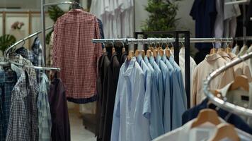 Elegant clothing store racks and hangers with a selection of shirts in various colors, creating a stylish and trendy fashion display in a refined retail space. Empty shopping center boutique. photo