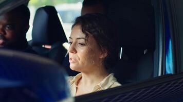 Woman buying car, doing test drive, evaluating if steering wheel feels comfortable, looking out for potential lag. Customers in vehicle with salesman driving to see how automobile reacts, camera A photo