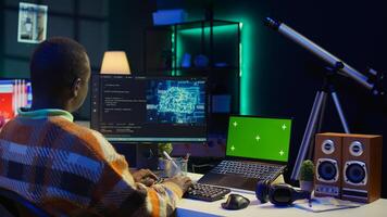 African american man using AI to develop a software system with chroma key on pc, cloud computing. Male IT programmer showing his skill in coding and cyber security, machine learning. Camera B. photo