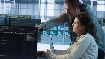 IT technicians in server farm brainstorming ways to repair equipment storing datasets. Colleagues at work in data center discussing how to mend rigs doing computational operations, camera A photo