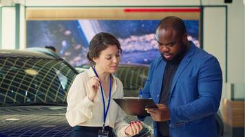 Saleswoman in car dealership signing contract with man after addressing concerns and providing compelling reasons for purchase. Agent completing necessary sale paperwork, shaking hands, camera A photo