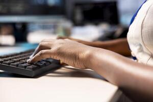 Engineer typing on keyboard, reconfiguring server farm to optimize it for data processing requirements of customers. Close up of employee working on PC to ensure data center operates efficiently photo