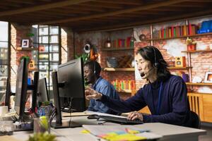Team of call center agents at office desk handling customer inquiries, complaints and support requests. Customer service coworkers assisting clients with issues related to products photo
