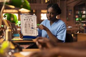 Black med school students team reading anatomy textbooks and thesis notes at the library, learning session for a successful career. Pupils focusing on exam preparation for their diploma. photo