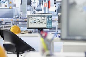 PC screen on desk in photovoltaics factory used to update software of robot arms placing solar panels on assembly lines. Computer display in empty facility used for upgrading solar plant machinery photo