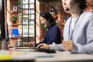 Jolly call center senior agent analyzes customer feedback, working to reduce issues. Joyous Asian customer service employee using problem solving skills to address customer needs photo
