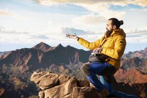 Trekking enthusiast captures his activity on using a drone footage, documenting the scenic mountain range valley. Filming beautiful aerial view vlog with remote control device. photo