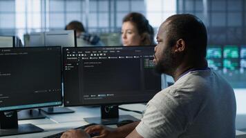 Admin in server hub tasked with protecting valuable data against hacking attack on computers. African american worker safeguarding data center against unauthorized access and vulnerabilities, camera A photo