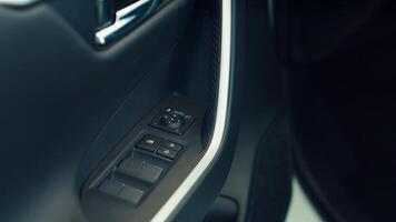 Details close up shot of car door lock controls handling opening and closing of windows and door providing safety and security from outside while driving. Panning shot of vehicle door buttons photo
