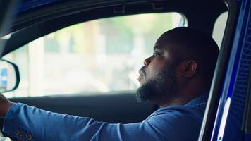 Man doing test drive, examining car before making purchase, exploring compartments and pushing buttons to make sure everything is working, checking how comfortable driving position is, camera A photo