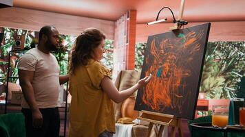 Team of artists in a gallery atelier working on new art piece, using finger painting technique for abstract creation. Blending acrylic paints with precision to create contemporary design. Camera B. photo
