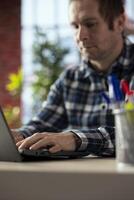Close up shot of businessperson at home office desk using laptop, drafting contracts. Worker typing on notebook keyboard, editing documents before sending final versions to external partners photo