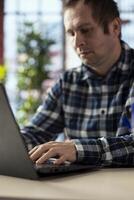 Employee in workspace using laptop, preparing presentation slides, inserting charts, adjusting layouts. Close up of man finishing company project, writing summaries, saving files, uploading materials photo