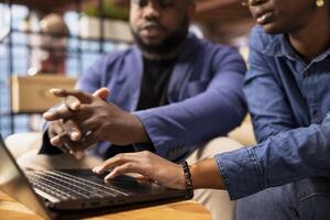 African American couple in their home space collaborate on a business project, using teamwork and digital online tools to enhance efficiency and career growth. Solving freelancing tasks. photo