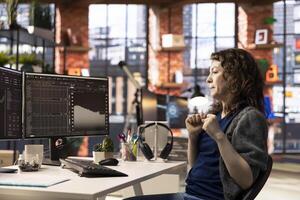 Joyful thrilled woman works on stock trading analysis browsing real time data on her monitors. The digital platform provides financial statistics, forex trends and investment insights. photo