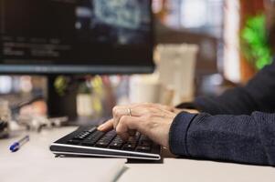 AI startup office software developer typing on computer keyboard, implementing machine learning. Close up of artificial intelligence tech venture IT professional working to fix code bugs on PC photo