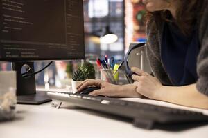 Female developer coding cloud computing applications on pc in a modern tech workspace. Woman IT specialist focuses on the software development process for productivity and innovation. photo