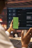 Woman sending vocal commands to AI LLM chatbot on PC using isolated screen smartphone. Close up of person speaking in mockup phone to communicate with artificial intelligence chatbot on computer photo
