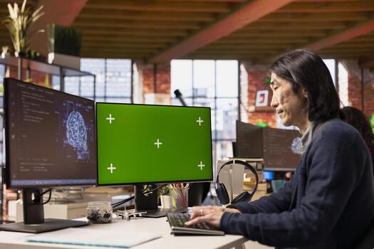 Software developer in pioneering technology startup using green screen computer to oversee artificial intelligence neural networks. Man in tech startup office using AI to build product on mockup PC photo