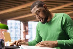 Man browsing though financial audit report files, feeling puzzled by confusing data. Stressed person doing his taxes, perplexed by paperwork documents needing to be completed photo