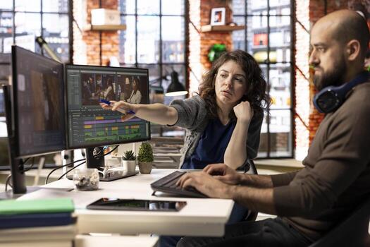 editors team working with AI chatbot and montage maker software, editing a background and mixing clips on dual monitors. Professional man and woman in creative process. photo