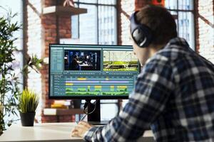 Remotely working videographer in home office doing montage using specialized software applications. editor using editing tools on PC to cut movie project footage in home office photo
