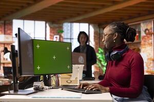 Isolated screen PC used by AI software developer working with artificial intelligence technology in tech startup. African american woman using chroma key computer to develop AI systems photo