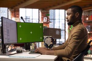 Developer using isolated screen PC display in startup office, debugging applications. IT professional doing code testing and quality assurance on chroma key computer monitor photo