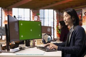 AI startup office chief technology officer building application on green screen computer. Senior developer working in artificial intelligence software development agency on chroma key PC photo