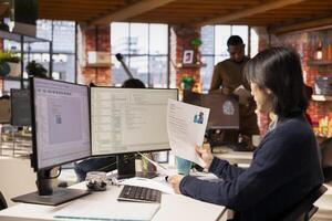 Tech startup HR senior manager vetting software development position applicants, ensuring their skills are strong enough match for role. Asian recruiter assessing candidate work experience, reading CV photo