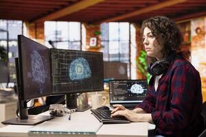 Woman in artificial intelligence focused startup office designing, coding and debugging applications in different software languages. IT expert doing code testing and quality assurance photo