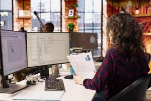 Tech startup company HR employee looking at CVs and doing background checks to potential job applicants. Technology business employer reading resumes of candidates for vacant position photo