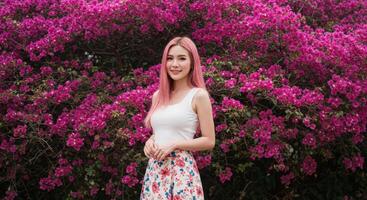 Thai Woman with Blonde Hair in White Top Posing in Colorful Flower Garden photo