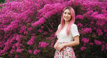 Thai Woman with Pink Hair in White Top Enjoying Colorful Flower Garden photo
