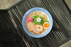 Delicious ramen soup with soft egg and pork meat in bowl photo