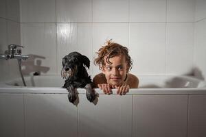 Boy with dog in bathtub photo