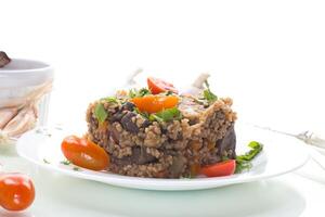 Quick and easy dinner.boiled bulgur in a plate with cherry tomatoes, isolated on white background photo