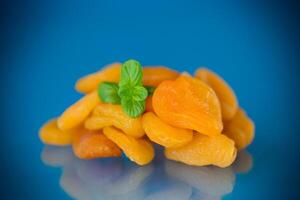 Natural dried apricots with a sprig of fresh mint in a studio shoot photo