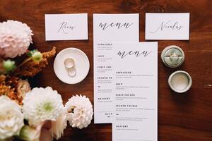 Amsterdam, Netherlands - June 5, 2024. Wedding rings on a saucer and in a box are on the holiday menu near the bouquet on the table. Top view photo