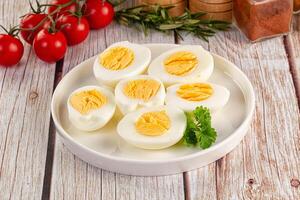 Hard boiled eggs on a plate with tomatoes and herbs photo