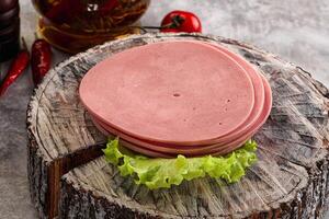 A stack of ham on a wooden block photo