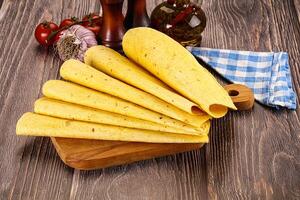 A wooden cutting board with a bunch of tortillas on it photo