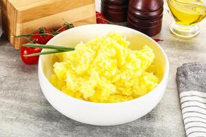 A bowl of mashed potatoes on a table photo