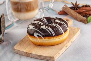 A chocolate donut on a wooden cutting board photo