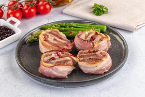 A plate with three pieces of bacon wrapped in asparagus photo