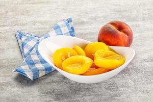 A bowl of peaches and a napkin on a table photo