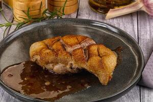 A piece of meat on a plate with some spices photo